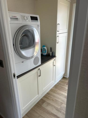 a washer and dryer in a kitchen with white cabinets at Family home in Northampton