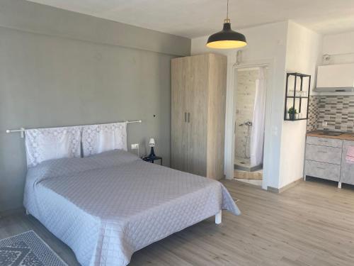a bedroom with a white bed and a kitchen at Maurizio's Villa in Yiáltra