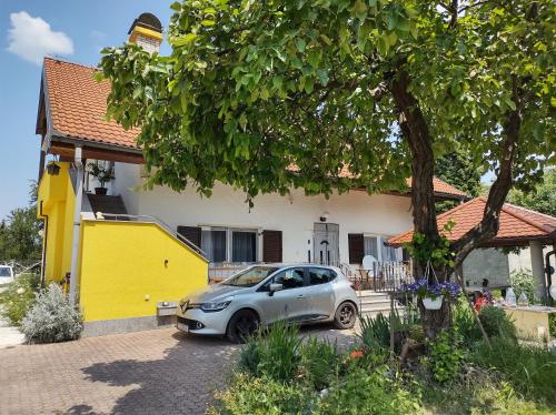 a car parked in front of a yellow house at Villa Drenje in Ključ Brdovečki