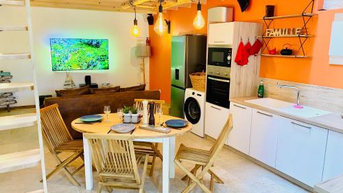 une cuisine avec une table et des chaises dans une pièce dans l'établissement L'atelier - Duplex Gîte de charme avec Spa La Rochelle, à Saint-Médard-dʼAunis