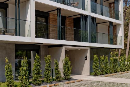 a building with trees in front of it at Apartamenty Wydma & Las BlueApart in Jastarnia