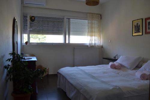 sissy's relaxing villa في أرتيميدا: غرفة نوم مع سرير مع وسادتين ورديتين عليه