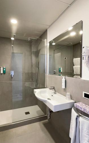 a bathroom with a sink and a shower and a mirror at Regina Cristina in Capri