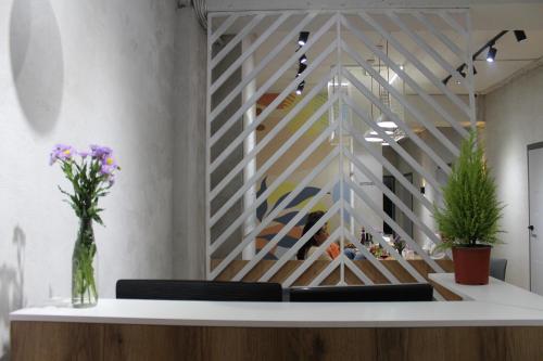 a lobby with a table with chairs and flowers at izzzi hostel in Bishkek