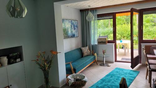 a living room with a blue couch and a table at Villa Blu in Sankt Kanzian
