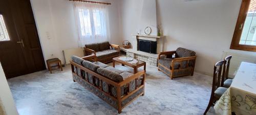 a living room with couches and a fireplace at Theofania's Marble House Meteora in Kastrákion