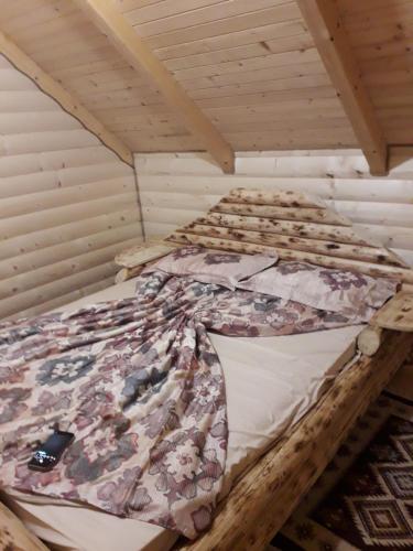 a bed in a room with a wooden ceiling at Brvnara Ibar in Rožaje