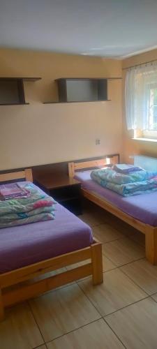 シェラツにあるNOCLEGI ELAのベッド2台が隣同士に設置された部屋です。