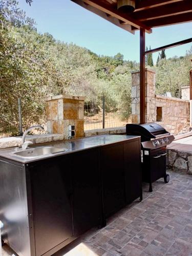 an outdoor kitchen with a stove and a grill at Oliveto e mare in Sivota