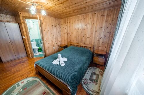 a bedroom with a bed in a wooden room at Сосновий Бір, Світязь in Svityazʼ