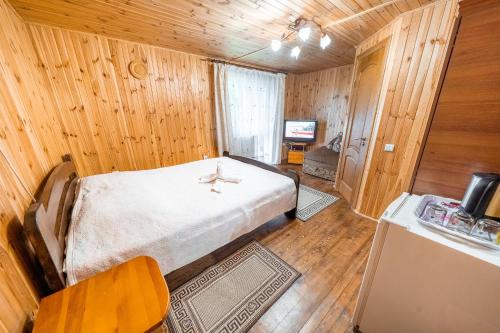 a bedroom with a bed in a wooden room at Сосновий Бір, Світязь in Svityazʼ