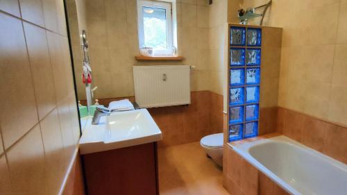 比亞韋斯托克的住宿－Leśny Apartament，浴室配有盥洗盆、卫生间和浴缸。