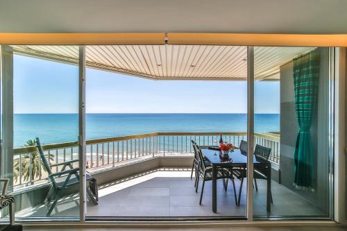 a balcony with a table and a view of the ocean at MAGNÍFICO APARTAMENTO - primera línea de mar in Calafell