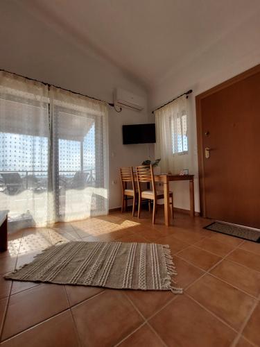 a living room with a table and chairs and a television at El Verde Apartments in Skala