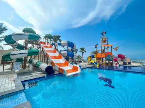 a pool with a water slide in a resort at Radisson Blu Hotel & Resort, Sohar in Sohar