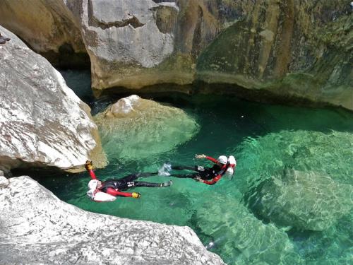 two people swimming in the water in a cave at Hôtel Terminus in Luz-Saint-Sauveur