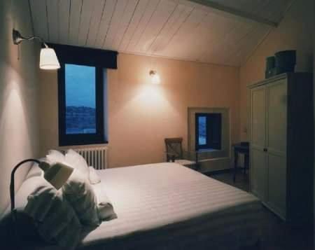 Un dormitorio con una gran cama blanca y una ventana en Caelum Hyblae, en Ragusa