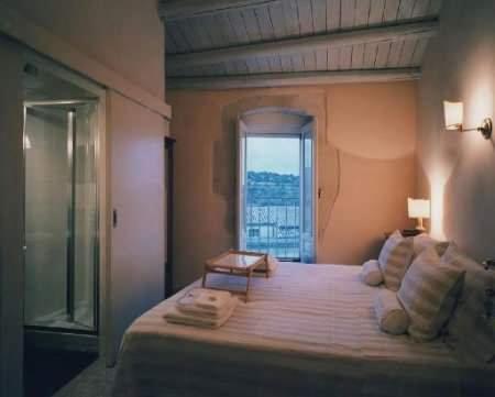 1 dormitorio con 1 cama grande y ventana en Caelum Hyblae, en Ragusa
