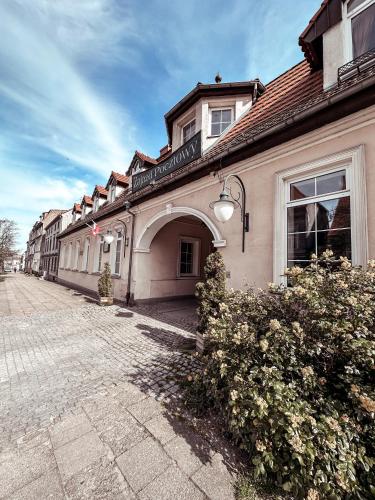 a building on a street with bushes in front of it at Hotel Zajazd Kultury, dawniej Pocztowy in Zielona Góra