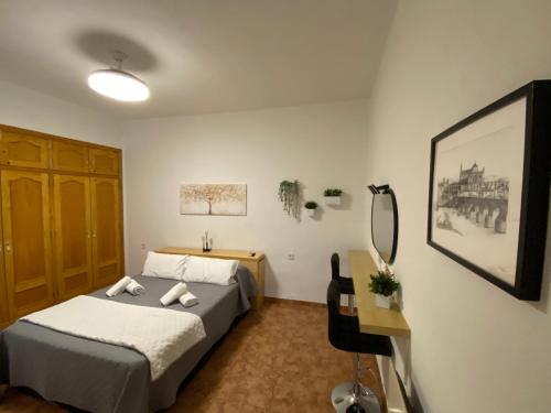 Pokój hotelowy z łóżkiem, biurkiem i biurkiem w obiekcie COSTASOL CORDOBA - Apartamento moderno - céntrico w Kordobie