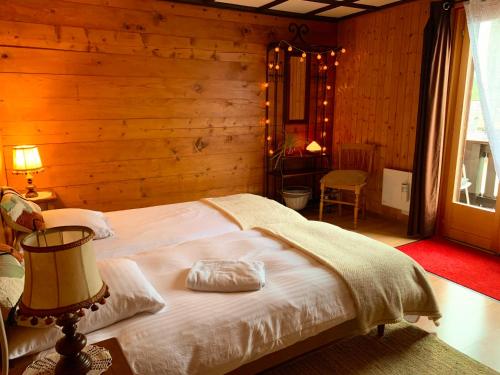 1 dormitorio con 1 cama en una habitación de madera en La Cure de Vernamiège en Vernamiège