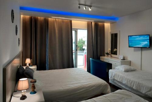 um quarto de hotel com duas camas e uma televisão em Luxury Apartment No. 202 (Napa Ace) em Agia Napa