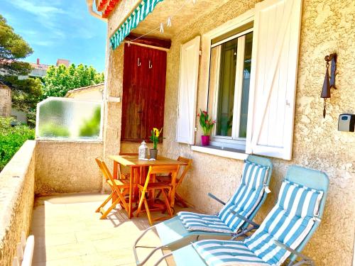 a patio with two chairs and a table and a window at Blue Summer Vibes Apartment for 4P, AC, balcony, parking, beach at 50m, SPA access -4 in La Ciotat