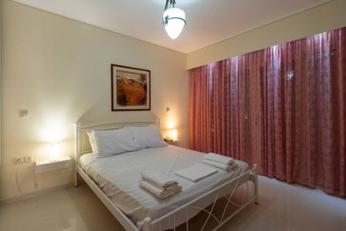 a bedroom with a bed and a window with red curtains at Glamour beautique villa in Akharnaí