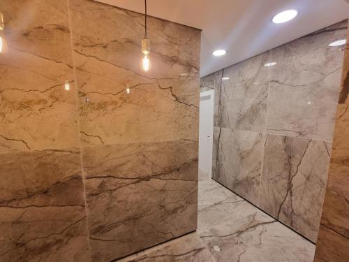 La salle de bains est pourvue d'un grand mur en marbre. dans l'établissement הברון baron, à Rishon LeẔiyyon