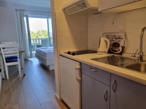 a kitchen with a sink and a stove top oven at Guesthouse Dominović in Brela