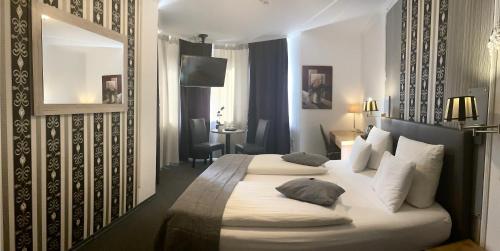 a hotel room with two beds and a mirror at Hotel Royal in Villingen-Schwenningen