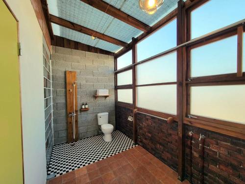 Habitación con ventanas y baño con aseo. en Railway Villa, en Taitung