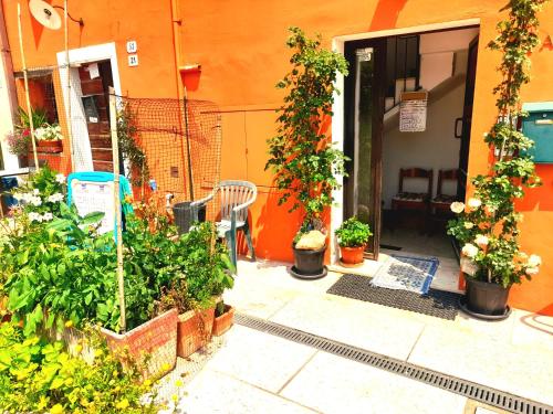 an orange building with a bunch of potted plants at ZANINA COUNTRY HOUSE in Peschiera del Garda