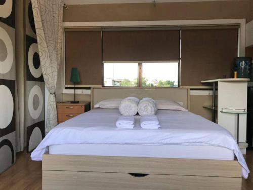 ein Schlafzimmer mit einem großen Bett mit Handtüchern darauf in der Unterkunft Mitra @Guesthouse B28-S in Batam Center
