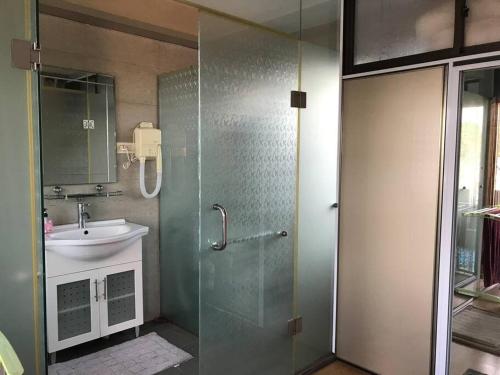 ein Bad mit einer Glasdusche und einem Waschbecken in der Unterkunft Mitra @Guesthouse B28-S in Batam Center