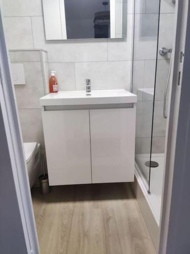 une salle de bain blanche avec un lavabo et une douche dans l'établissement Sausset-les-pins, T2 bord de mer, à Sausset-les-Pins