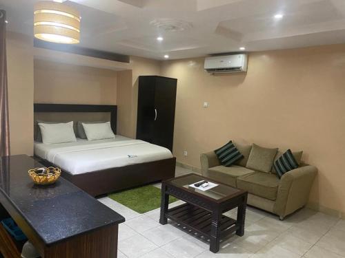 een hotelkamer met een bed en een bank bij Studio B, (Studio Apartment) Hillside Gardens in Lagos
