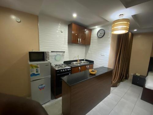 una cocina con refrigerador y estufa horno superior en Studio B, (Studio Apartment) Hillside Gardens, en Lagos