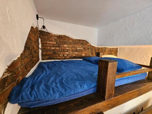 sypialnia z niebieskim łóżkiem z ceglaną ścianą w obiekcie Loft w mieście Sosnowiec