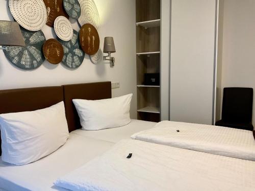 two beds in a room with plates on the wall at Hotel Royal in Villingen-Schwenningen