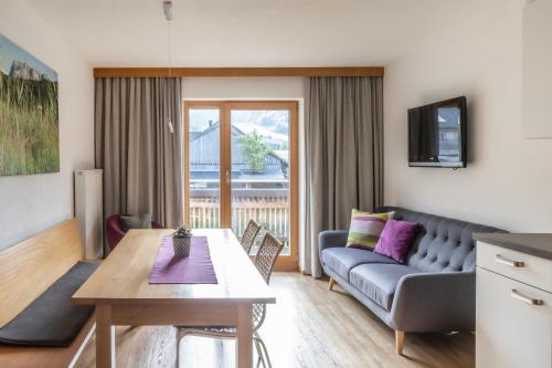 ein Wohnzimmer mit einem Sofa und einem Tisch in der Unterkunft Rössle Appartement in Bezau