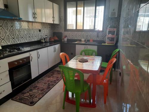 een keuken met een tafel en stoelen bij BOUZNIKA in Bouznika
