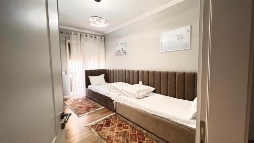een kleine slaapkamer met een bed en een raam bij Zeus Tirana Suite in Tirana