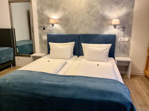 a large bed with a blue headboard in a room at Hotel Royal in Villingen-Schwenningen