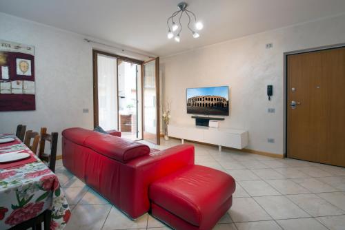 a living room with a red couch and a tv at Casa vacanza Simona in Salionze