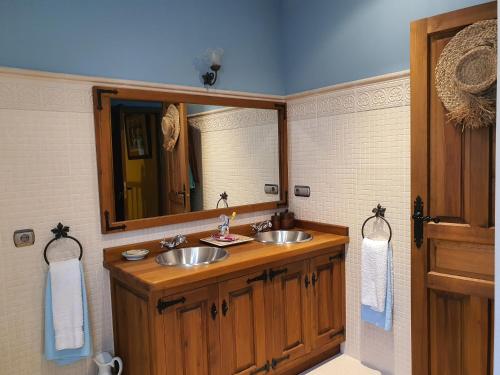 La salle de bains est pourvue de 2 lavabos et d'un miroir. dans l'établissement El lagar de Lolo, à Hontanares de Eresma