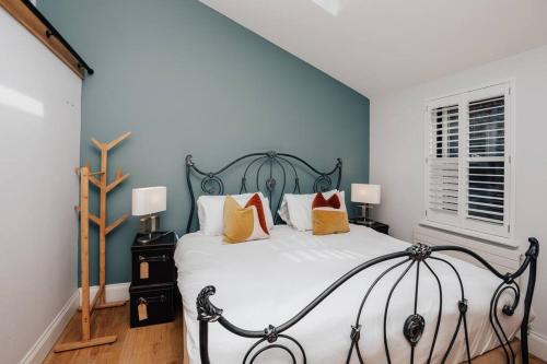 a bedroom with a large bed with blue walls at Henley Gardens in Henley on Thames