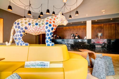 愛丁堡的住宿－派克斯愛丁堡城市酒店，黄沙发上马的雕像
