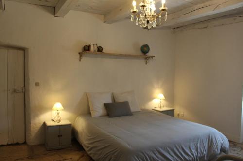 1 dormitorio con 1 cama y 2 mesas con lámparas en Les Romarins B&B, 10 min d'Uzès, piscine et grand jardin, Table d'hôte, en Uzès