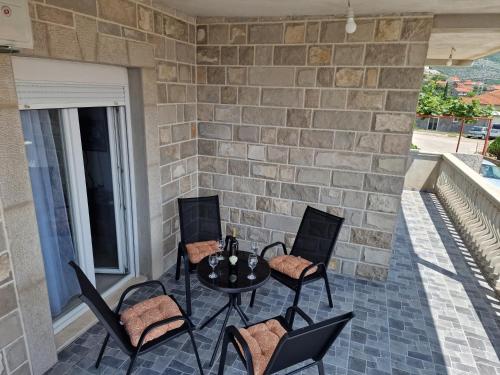 a patio with chairs and a table and a brick wall at VistaRelax in Trebinje
